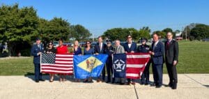 District and county officials gathered for a photo in front of the USA, Delaware, and 9/11 Remembrance flags.
