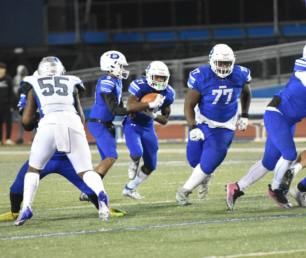 Dover Football lineman Jason Hoskins out in front to block as quartbck Nahseem Cosme hands the ball off to running back Jakwon Kilby photo by Ben Fulton